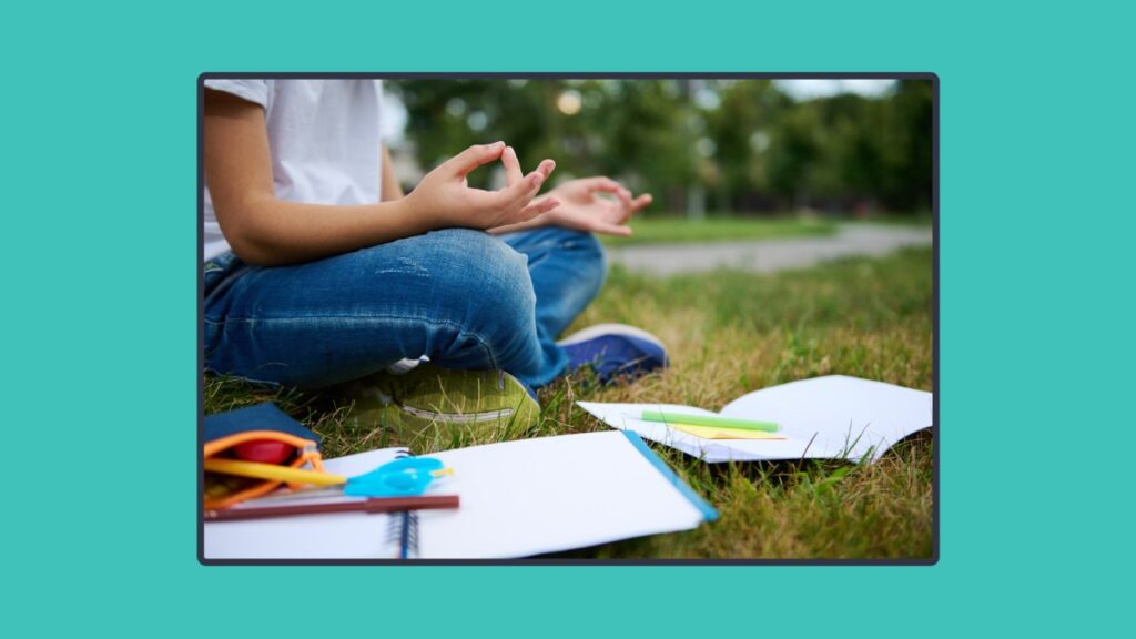 Student doing meditation with study books at her feet