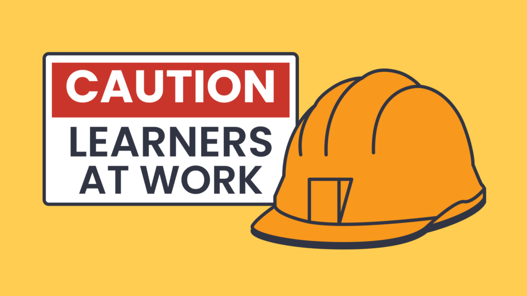 Caution sign with a construction helmet, representing hands-on and practical classroom learning.