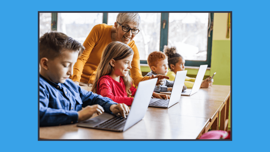 A photo os students on a computer and a teacher assisting them