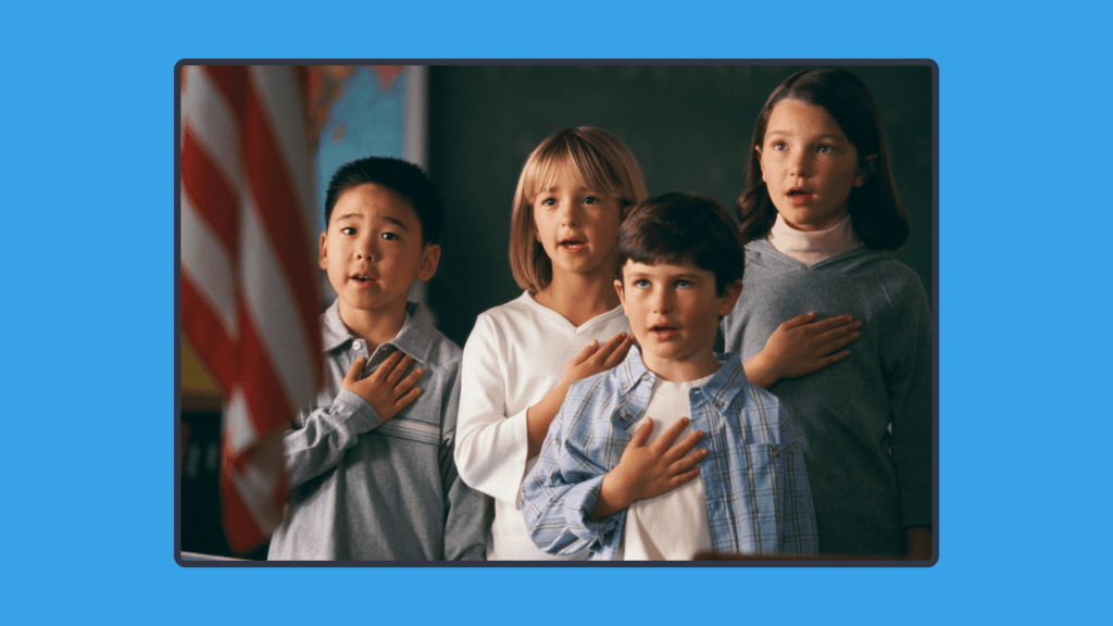 A photo of children putting their right hand to their chest in front of the American flag
